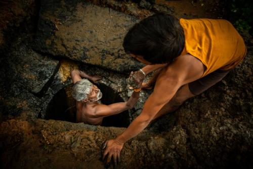 Kaverappa being lifted out of a pit by Muniraju in Bengaluru. By: Water Aid / CS Sharada Prasad 